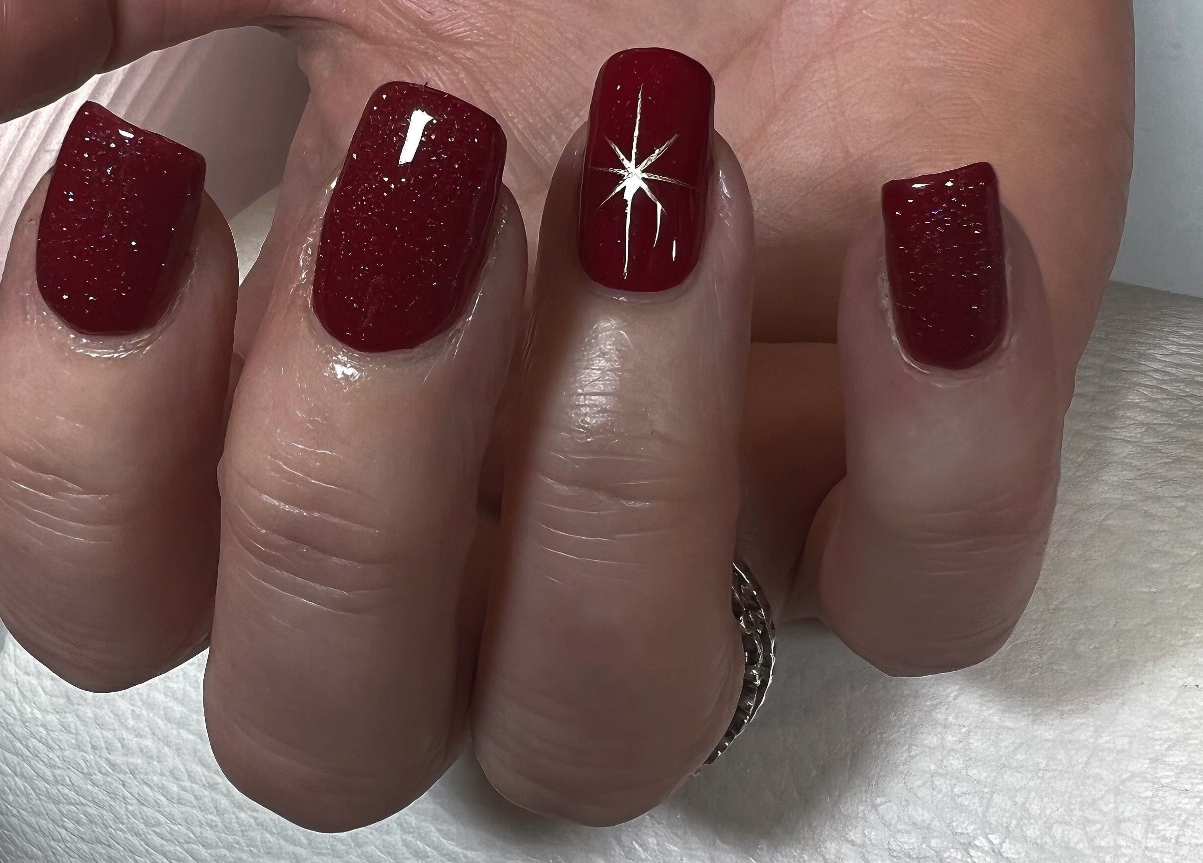 Elegant red glitter nails with star design at Kerisbeauty, Swindon, England, GB salon.
