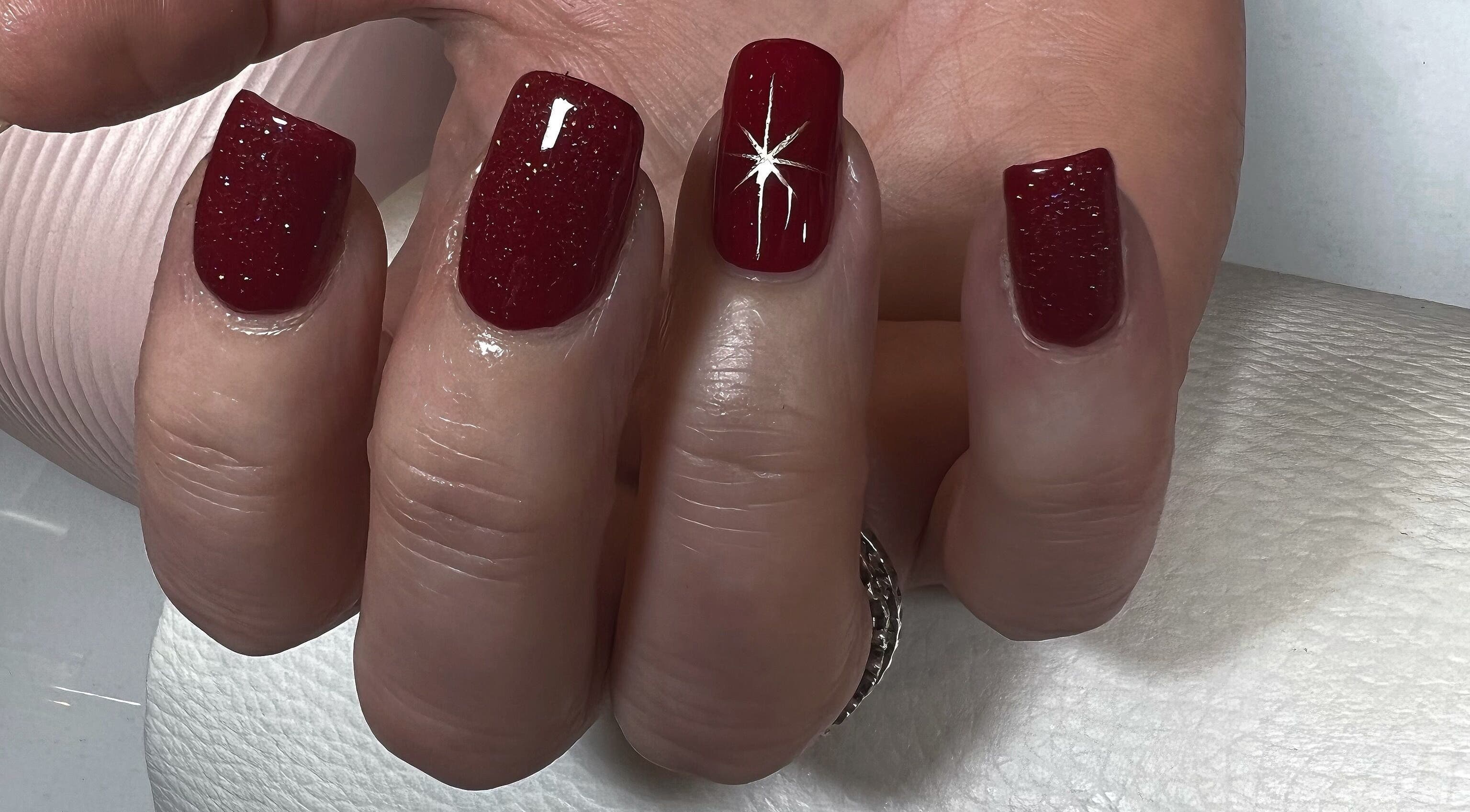 Elegant red glitter nails with star design at Kerisbeauty, Swindon, England, GB salon.
