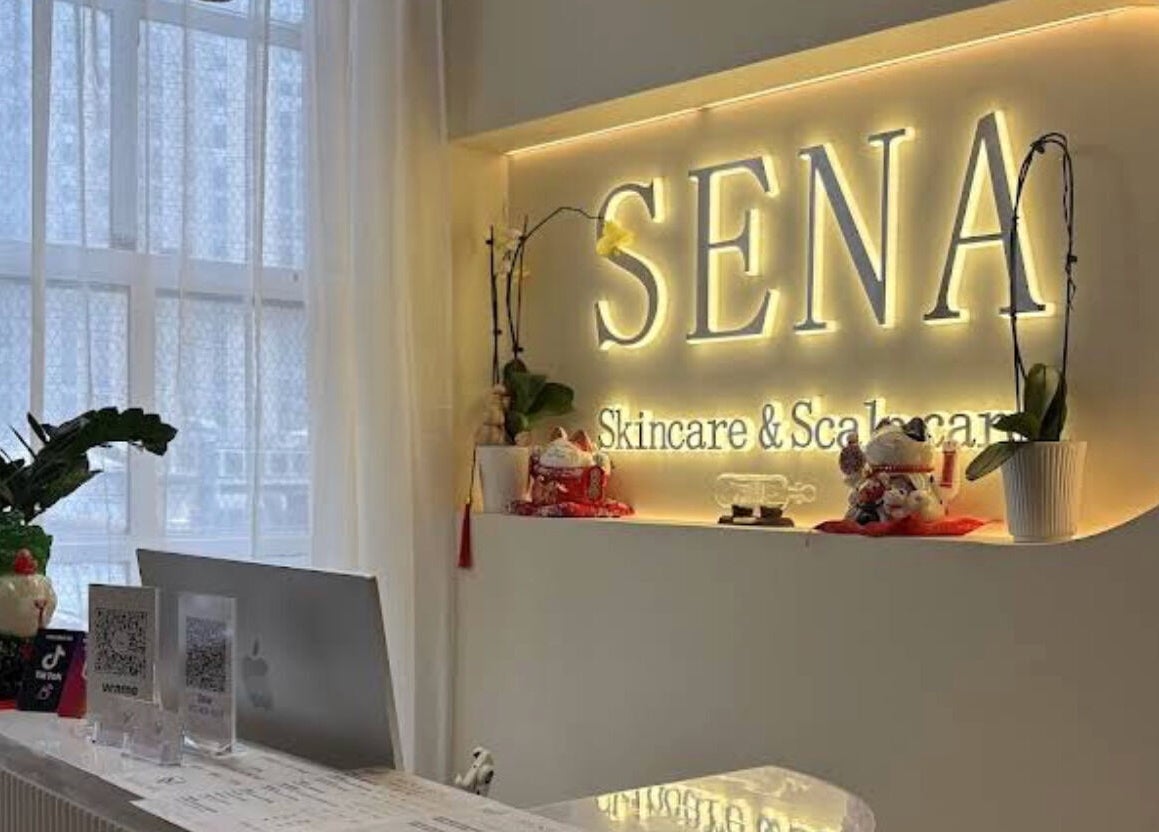 Reception area of SENA in New York, New York, US, featuring elegant decor and illuminated signage.
