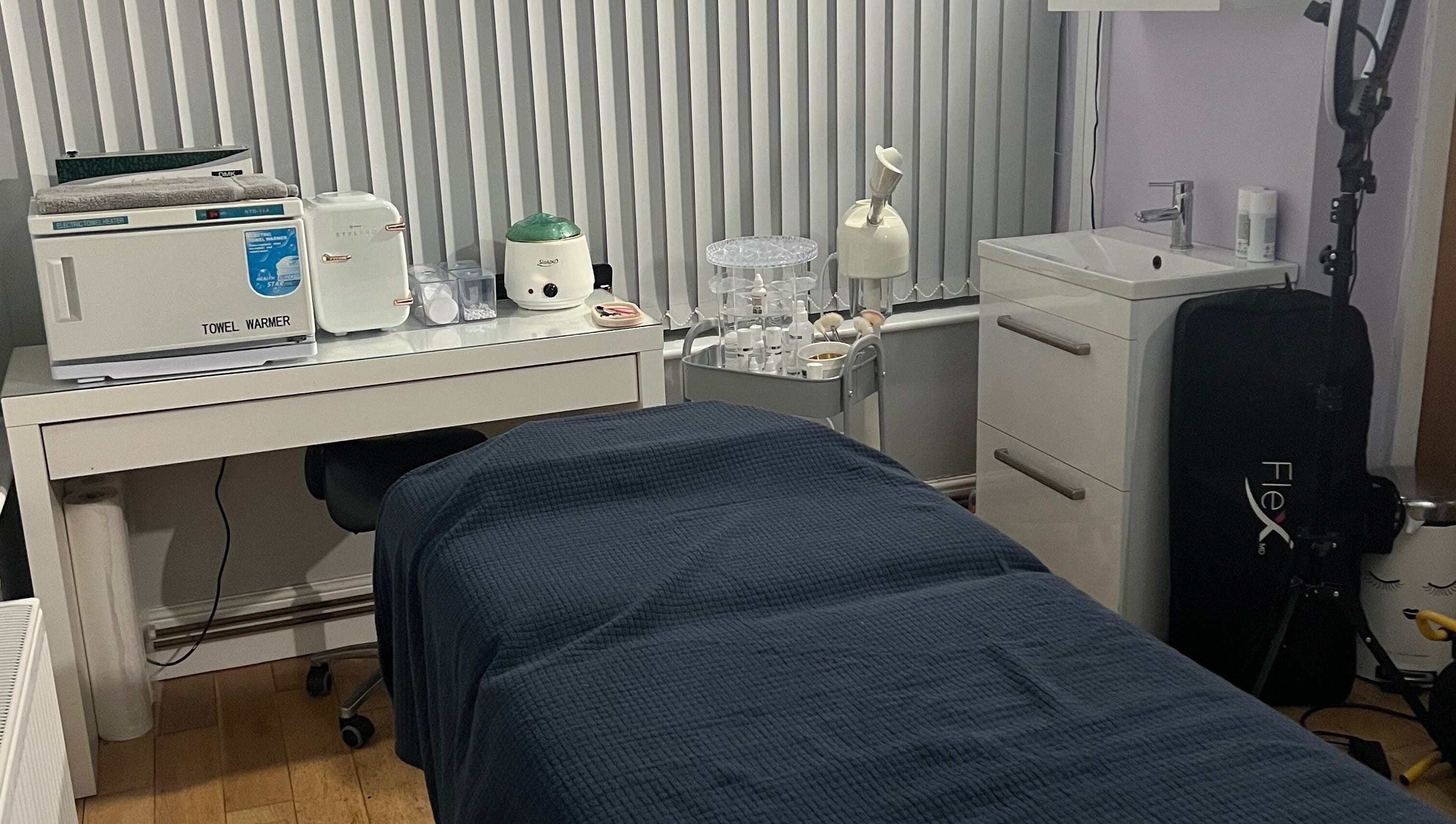 Cozy treatment room at Rejuvin8, Slyne, England, GB, featuring a massage table and towel warmer.