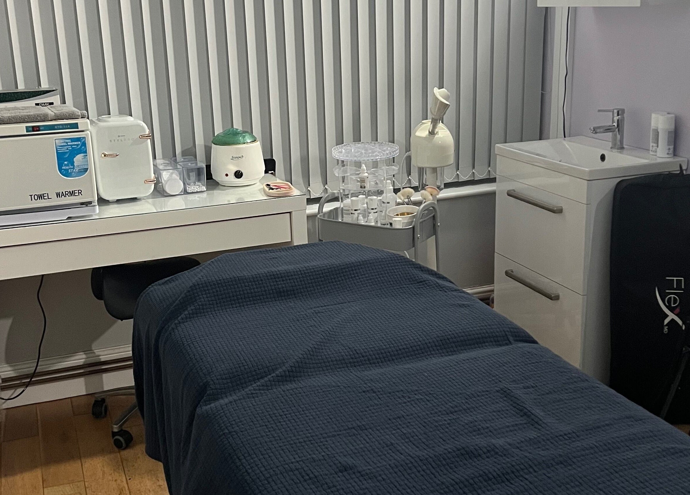 Cozy treatment room at Rejuvin8, Slyne, England, GB, featuring a massage table and towel warmer.