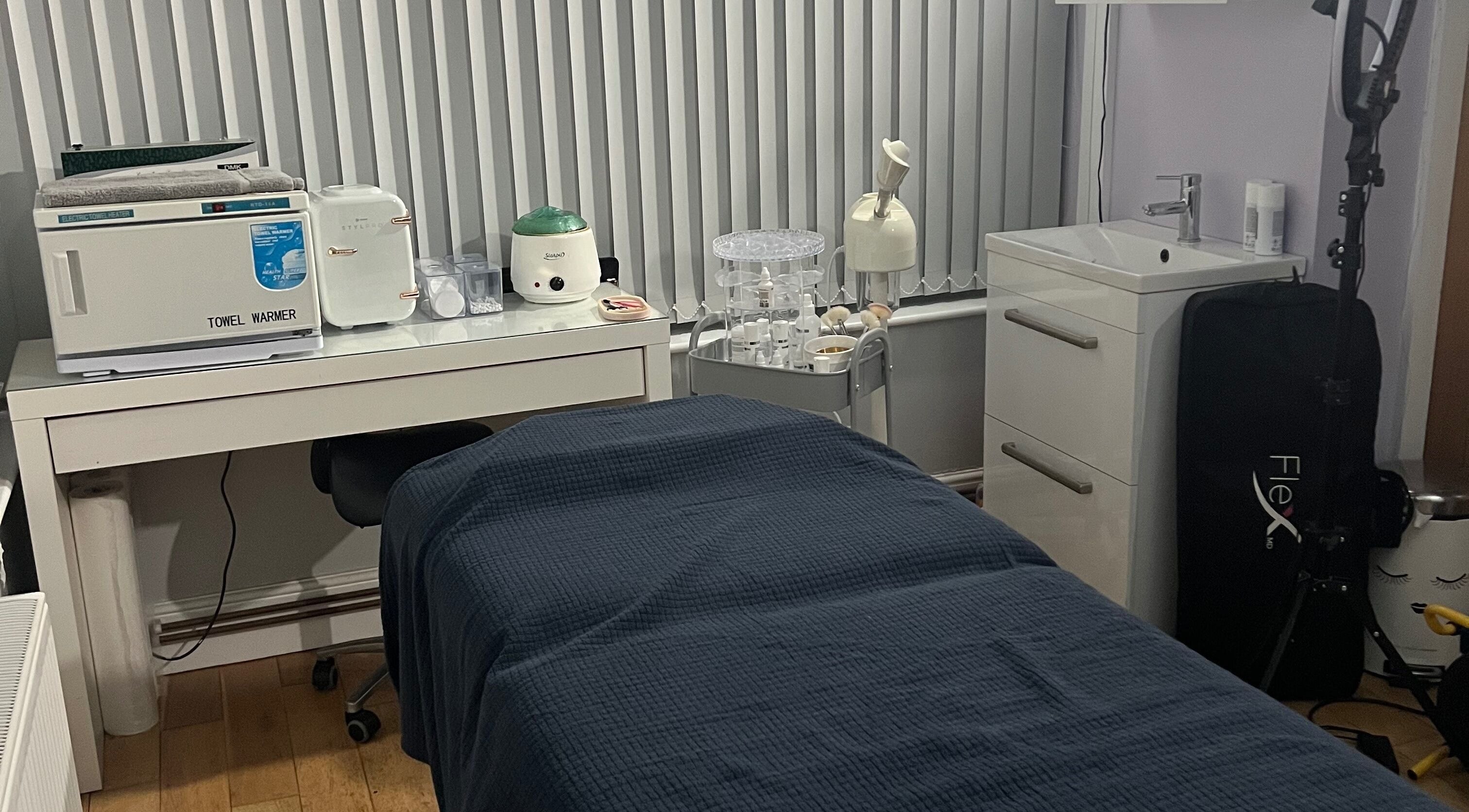 Cozy treatment room at Rejuvin8, Slyne, England, GB, featuring a massage table and towel warmer.