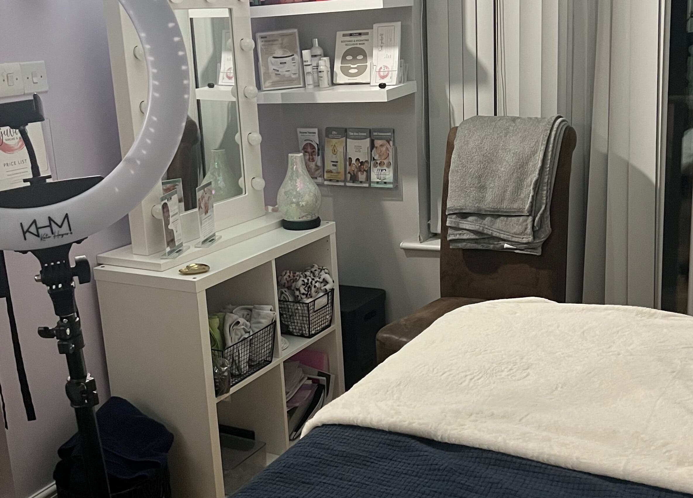 Cozy treatment room at Rejuvin8, Slyne, England, GB, featuring a massage bed, ring light, and beauty products.