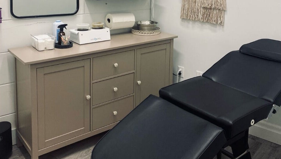 Comfortable treatment room at The Sugar Lounge in St. Thomas, Ontario, CA with massage bed and sleek decor.