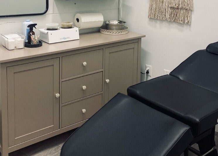 Comfortable treatment room at The Sugar Lounge in St. Thomas, Ontario, CA with massage bed and sleek decor.