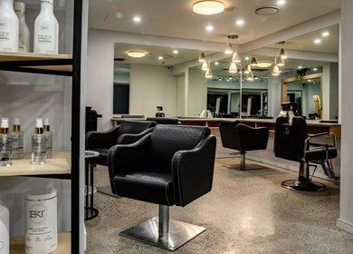 Elegant salon interior at BKT BEAUTY in Sydney, NSW, AU featuring luxury chairs and hair products.