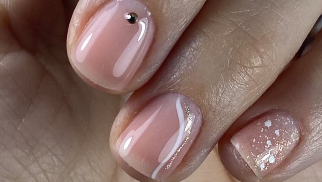 Manucure élégante chez Neïlys’SG, Soissons, Hauts-de-france, FR, avec vernis rose pâle et décoration brillante.