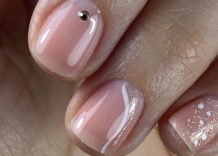 Manucure élégante chez Neïlys’SG, Soissons, Hauts-de-france, FR, avec vernis rose pâle et décoration brillante.