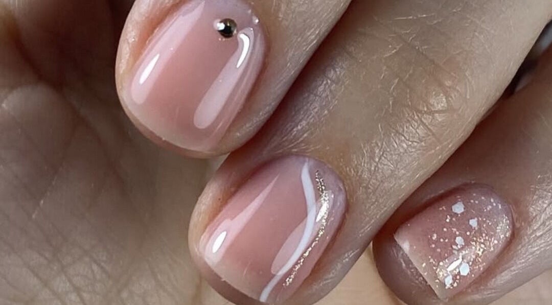 Manucure élégante chez Neïlys’SG, Soissons, Hauts-de-france, FR, avec vernis rose pâle et décoration brillante.