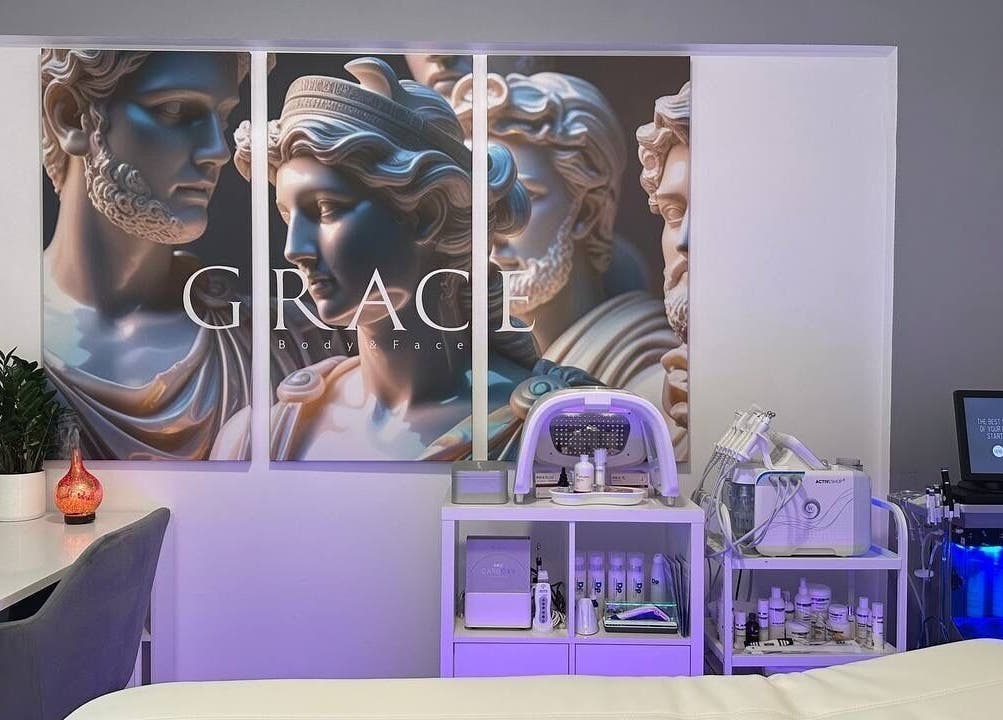 Decorated treatment room at GRACE body&face, Glyfada, GR showcasing elegant Greek-themed wall art.