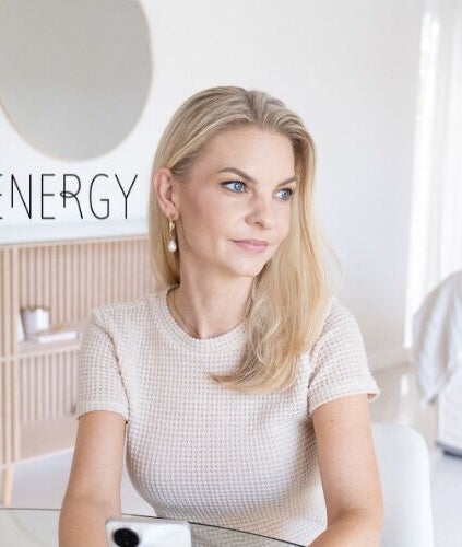 Woman sitting elegantly at Skin Energy, Cape Town, Western Cape, ZA, exuding calm and sophistication.