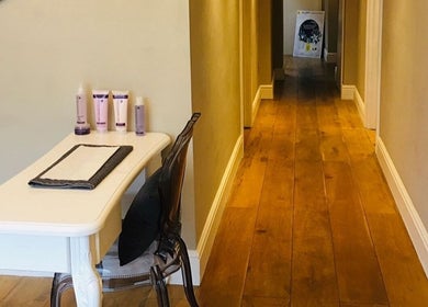 Elegant hallway at Cortés & Co Medispa, Usk, Wales, GB featuring sleek furniture and wellness products.