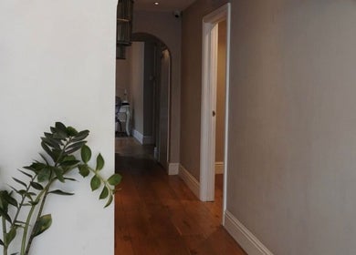 Serene hallway at Cortés & Co Medispa, Usk, Wales, GB, featuring elegant decor and lush greenery.
