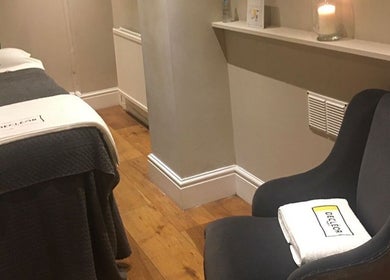 Relaxing treatment room at Cortés & Co Medispa, Usk, Wales, GB, featuring a therapy bed and cozy chair.