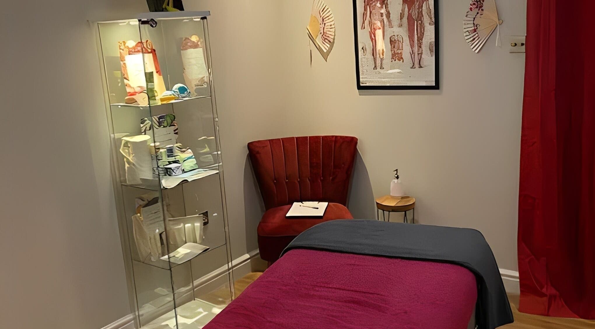 Cozy therapy room at Cherry Blossom Therapies, Abernethy, Scotland, GB with a red chair and massage bed.