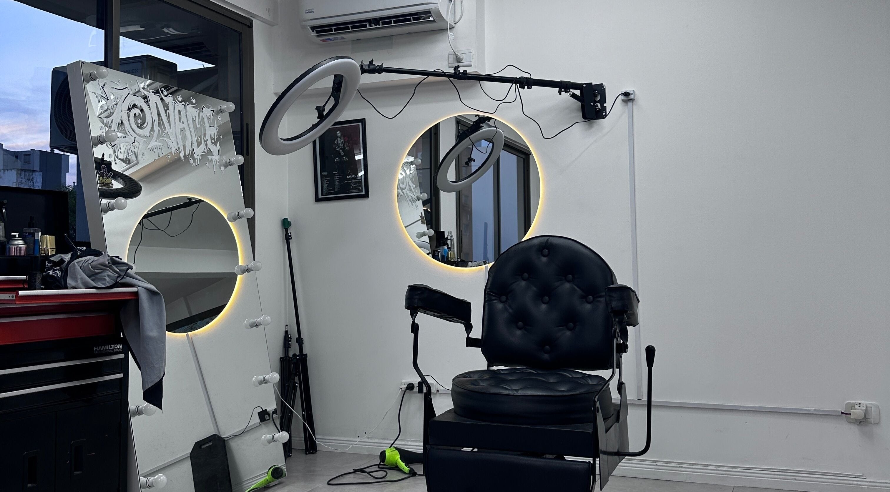 Interior moderno de Zonace Studio en Buenos Aires, con silla de peluquería y espejos iluminados.