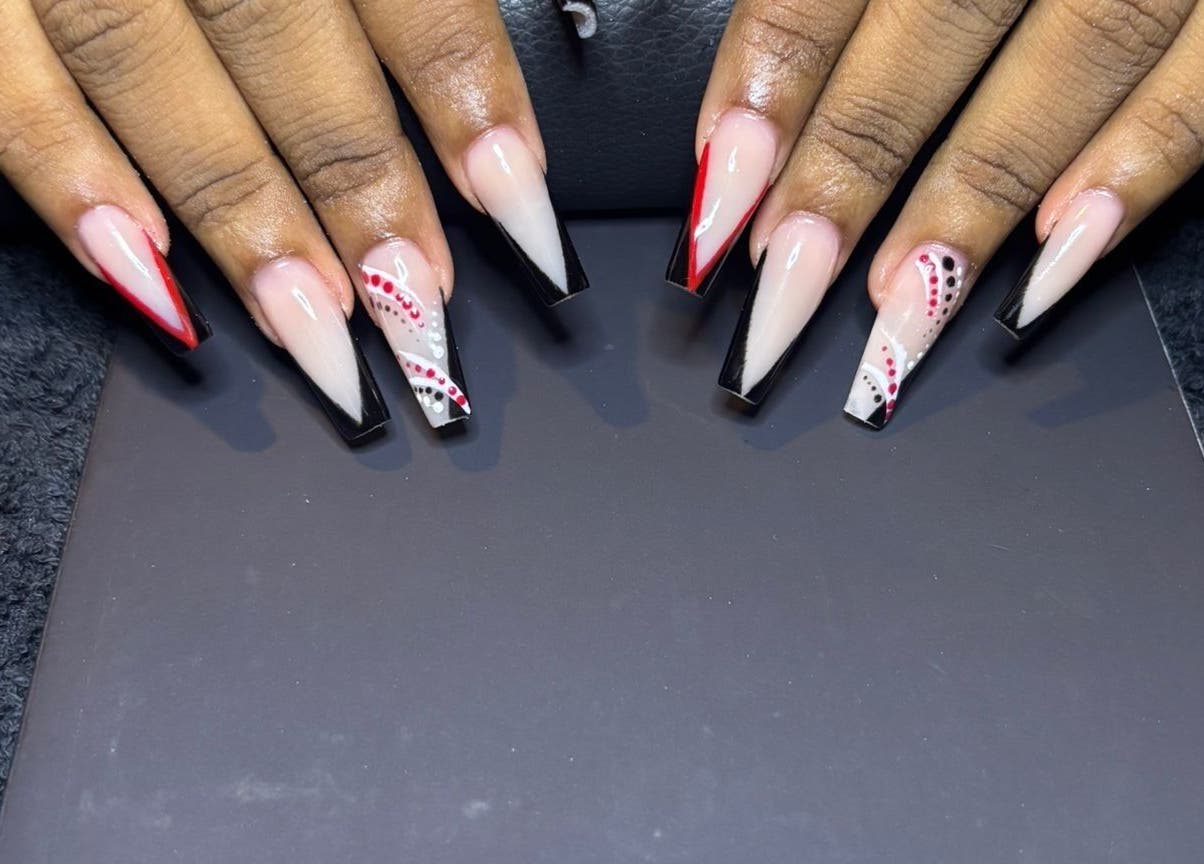 Elegant nail art with red and black designs at STUDIO 10, FREEPORT, Grand Bahama, BS.