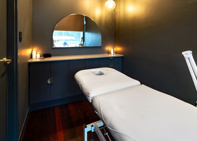 Serene treatment room at Breathe Beauty, Wembley, Western Australia, featuring a massage table and calming decor.
