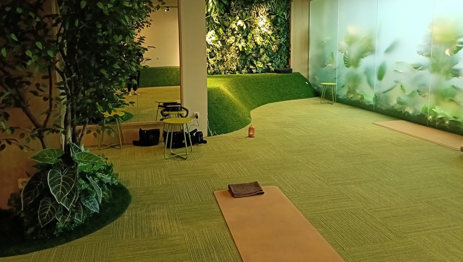 Tranquil yoga space at Haru Fit Tokyo, Jakarta Selatan, DKI Jakarta, ID, featuring lush greenery and mats.