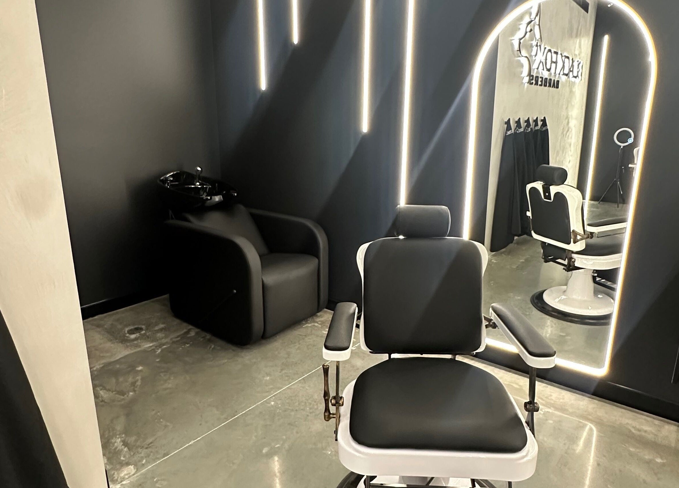 Modern barber chair at Black Fox Barbers, Pimpama, Queensland, AU, illuminated by sleek lighting and elegant decor.