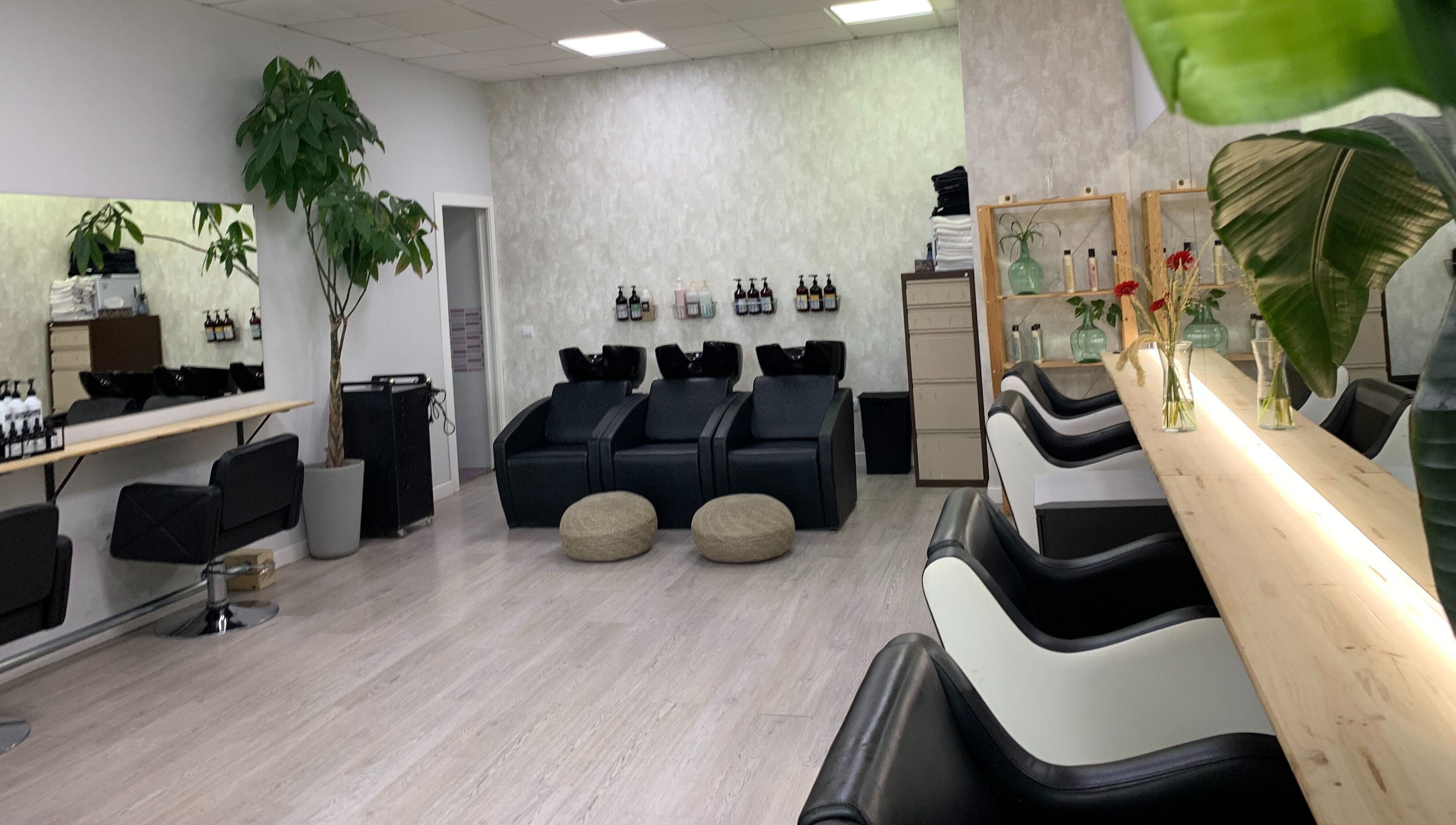 Interior moderno de Ío Salón en Madrid, Comunidad De Madrid, ES, con sillas de peluquería y decoración elegante.