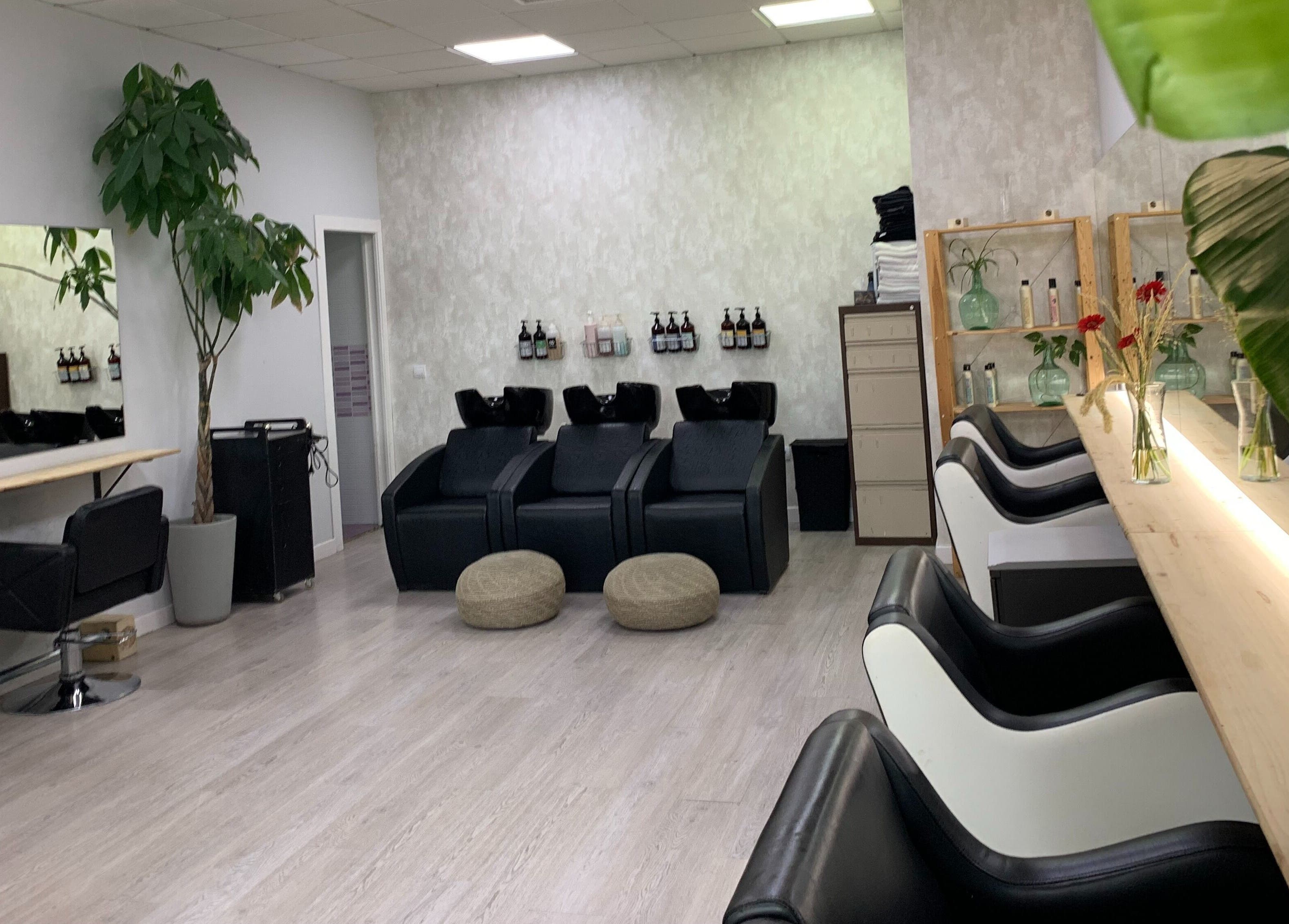 Interior moderno de Ío Salón en Madrid, Comunidad De Madrid, ES, con sillas de peluquería y decoración elegante.