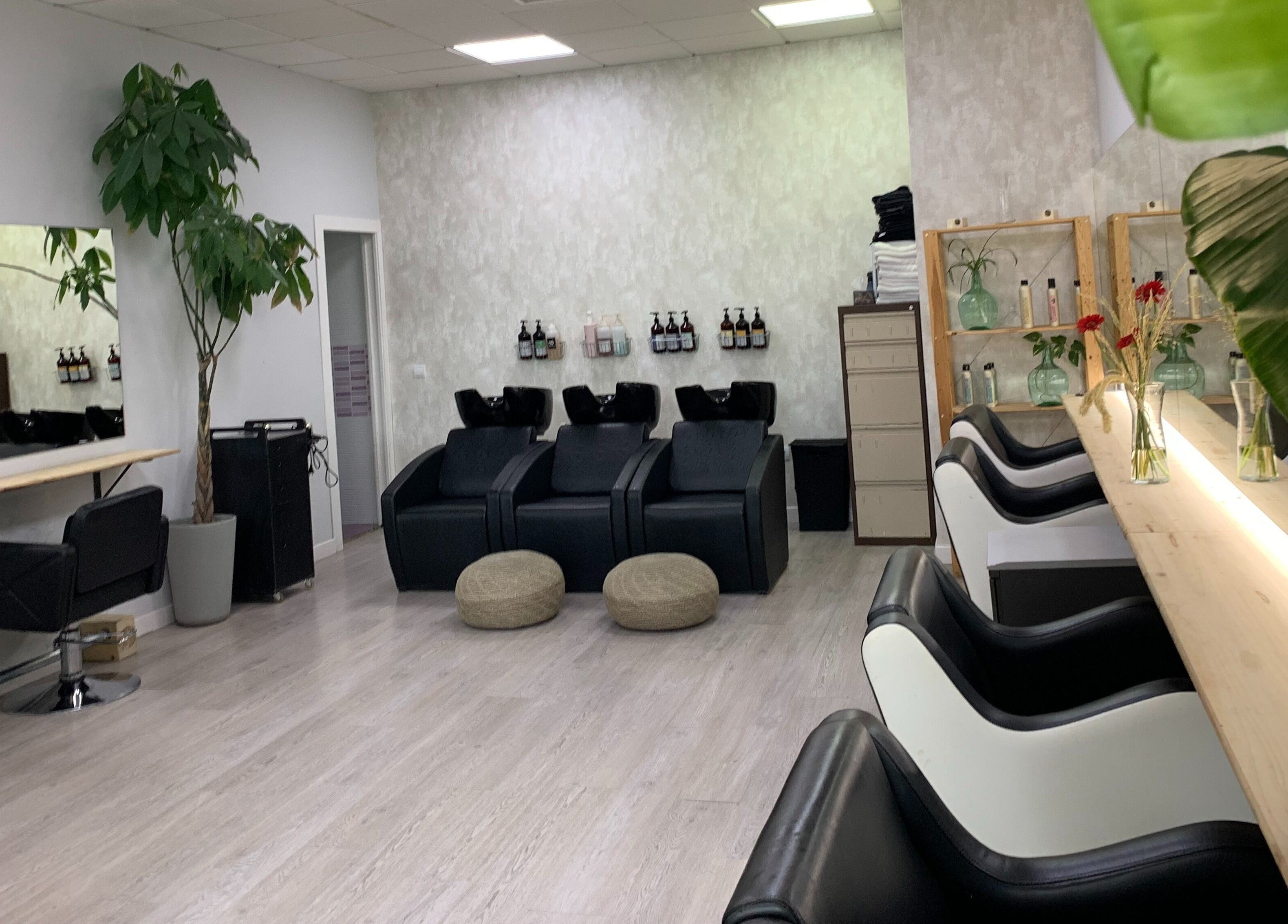 Interior moderno de Ío Salón en Madrid, Comunidad De Madrid, ES, con sillas de peluquería y decoración elegante.