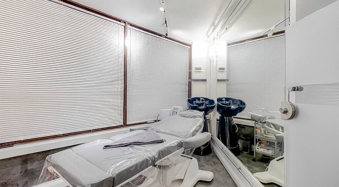 Spa treatment room at Beautybase Covent Garden, London, England, GB, featuring a modern massage bed and mirrors.