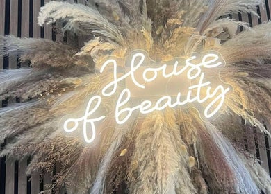 Illuminated neon sign 'House of Beauty' with pampas grass at Beauty By Ang, Plymouth, England, GB.