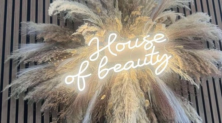 Illuminated neon sign 'House of Beauty' with pampas grass at Beauty By Ang, Plymouth, England, GB.