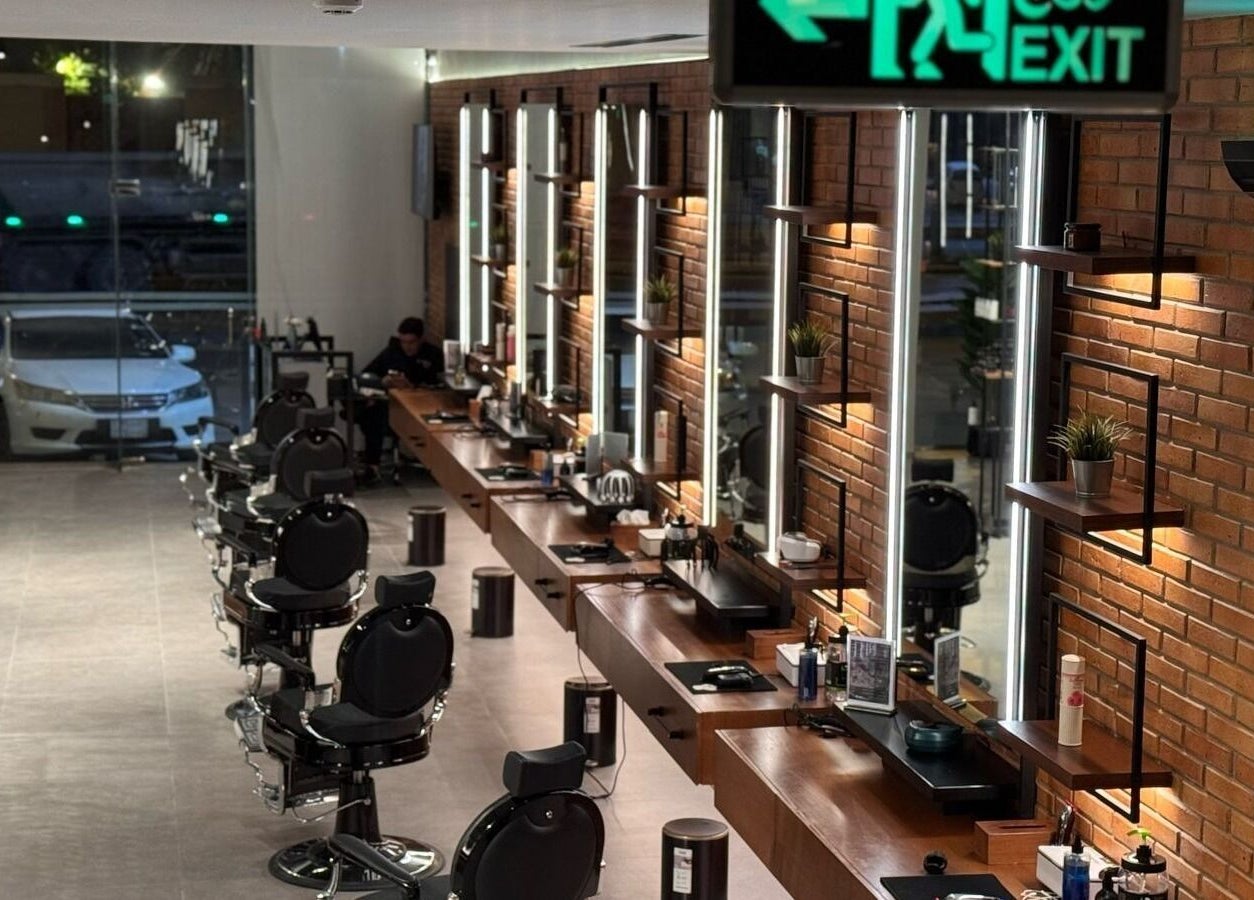 Contemporary interior of D Van Barbershop in Riyadh Province, SA with sleek styling stations.