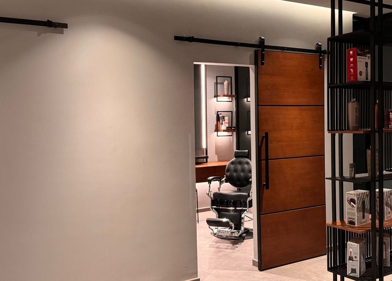 Inside D Van Barbershop, Riyadh; a sleek interior with a barber chair and modern shelving.