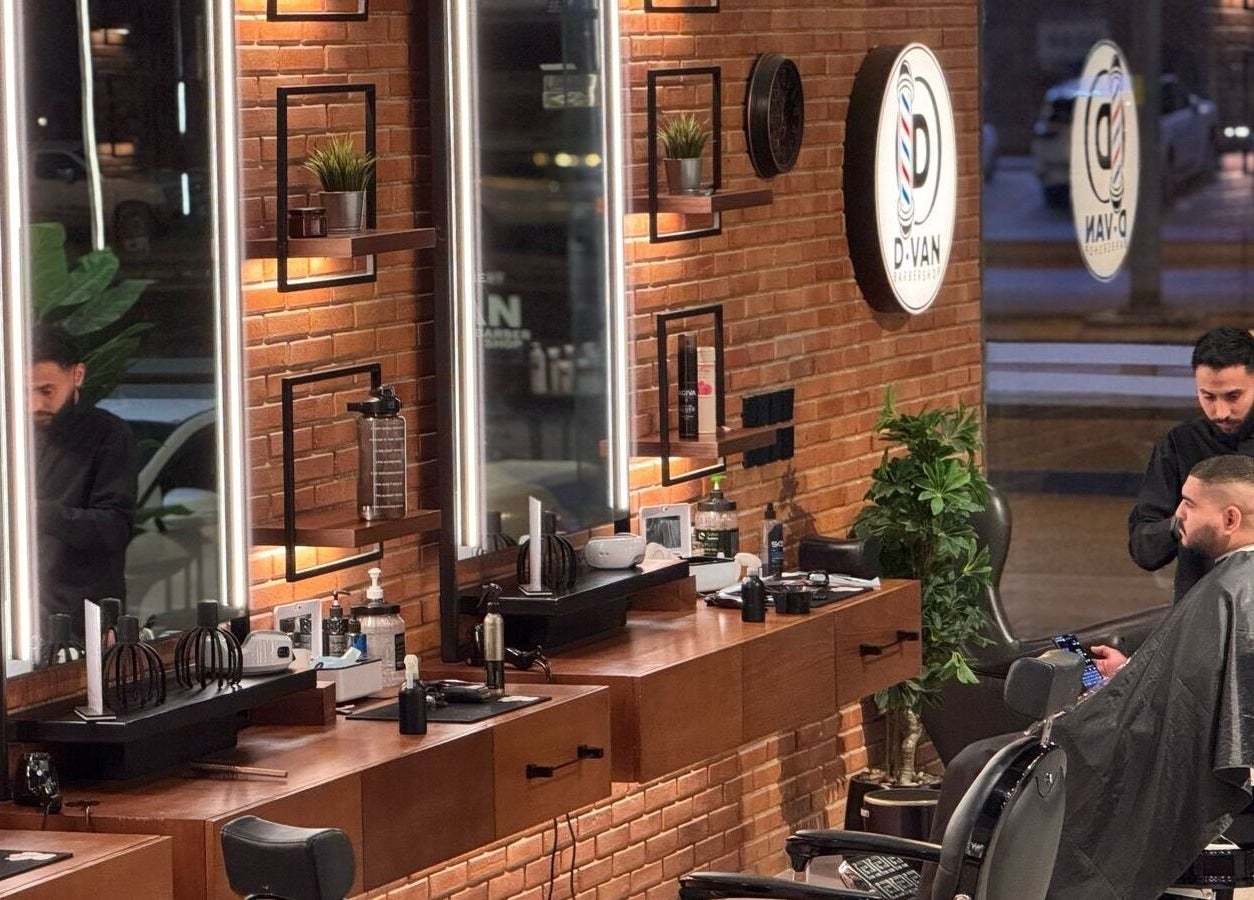 Barber providing service at D Van Barbershop, Riyadh, Riyadh Province, SA, with modern interior decor.