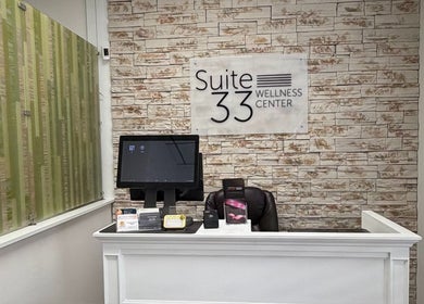 Reception at Bare Essence Spa, Gulf Breeze, Florida, US with elegant stone wall and modern decor.