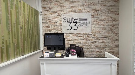 Reception at Bare Essence Spa, Gulf Breeze, Florida, US with elegant stone wall and modern decor.