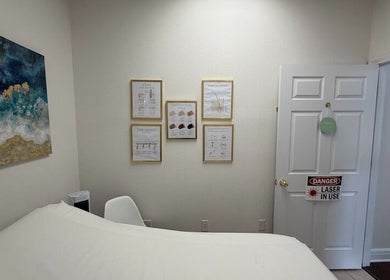 Tranquil treatment room at Bare Essence Spa, Gulf Breeze, Florida, US, featuring calming decor and informative posters.