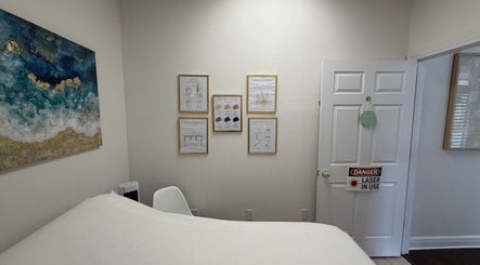 Tranquil treatment room at Bare Essence Spa, Gulf Breeze, Florida, US, featuring calming decor and informative posters.