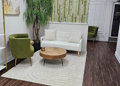 Chic seating area at Bare Essence Spa, Gulf Breeze, Florida, US with modern decor and greenery.