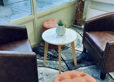 Inviting seating area at Angelite Esthetics in Toronto, Ontario, CA with brown chairs, table, and decor.
