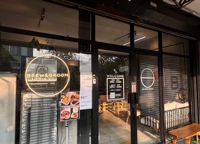 Entrance of Brew&Groom (Barber & Coffee Gombak) in Kuala Lumpur, MY showcasing glass doors and signage.