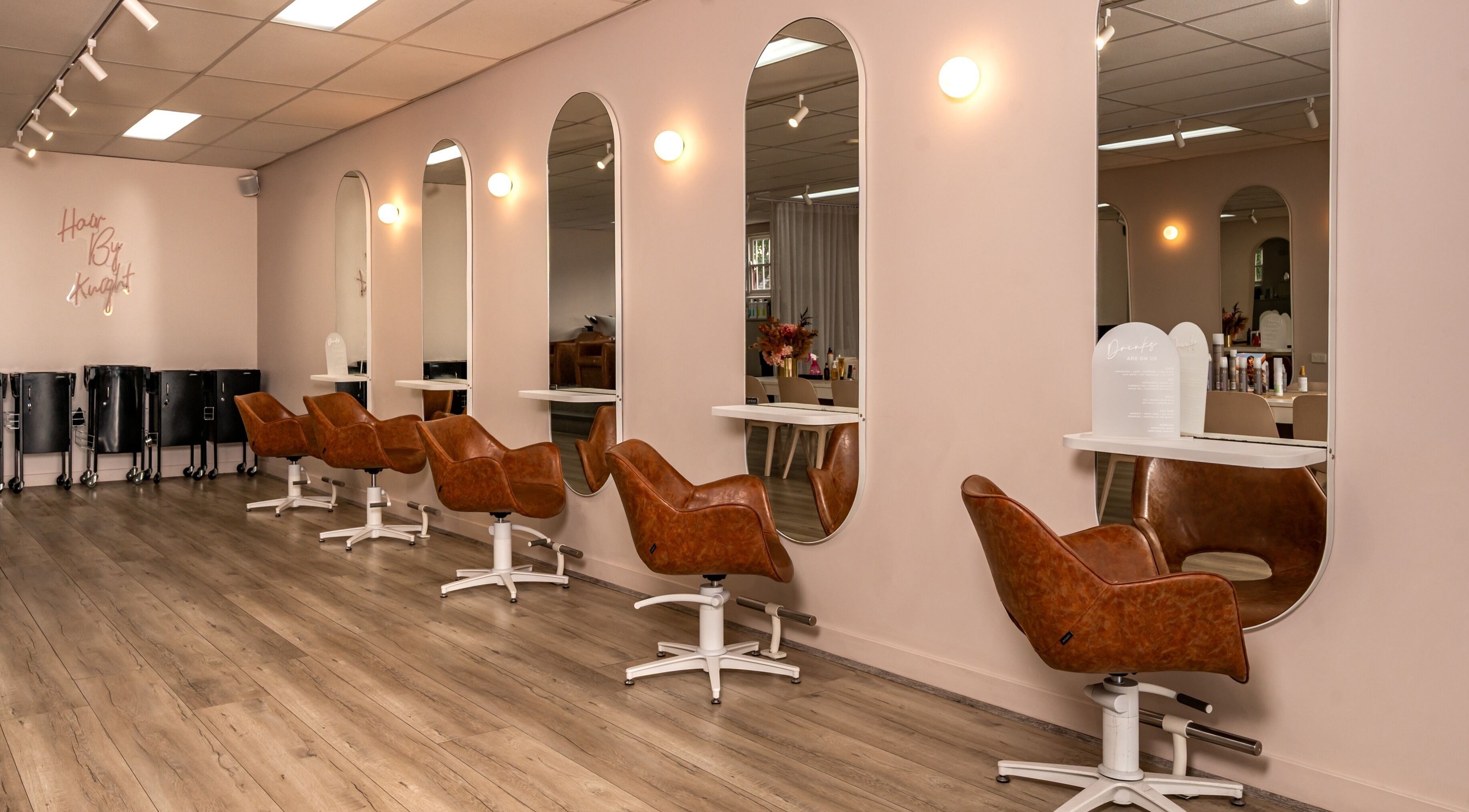 Modern salon interior at Hair by Knight in Melbourne, Victoria, AU with stylish chairs and mirrors.