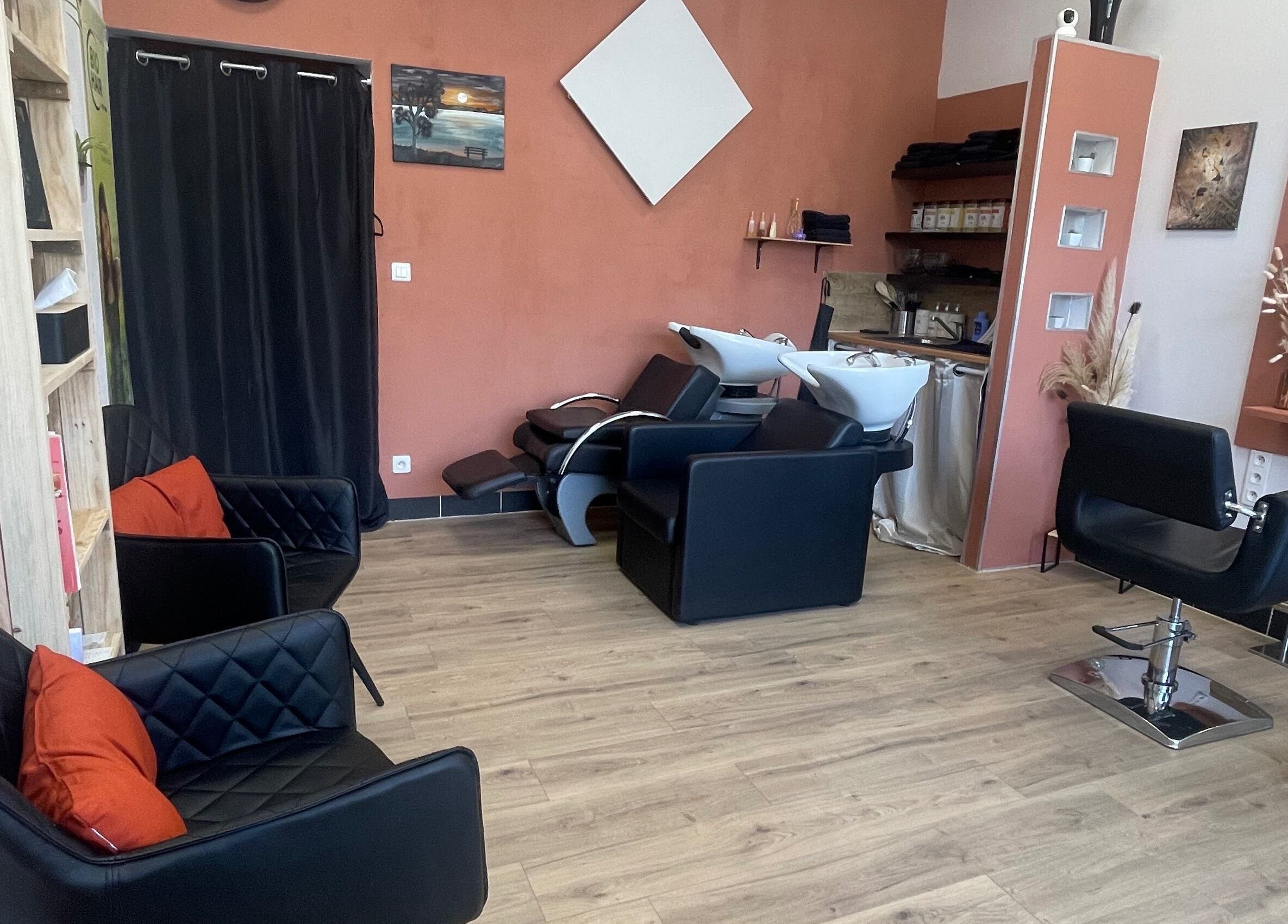 Intérieur élégant de Coiffure By Cha à Uzer, Auvergne-rhône-alpes, FR, avec fauteuils noirs.