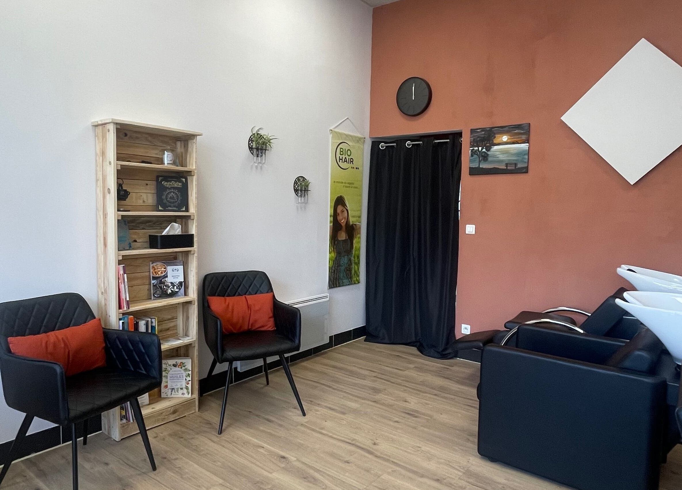 Espace élégant chez Coiffure By Cha, Uzer, Auvergne-rhône-alpes, FR, avec fauteuils noirs et étagères en bois.