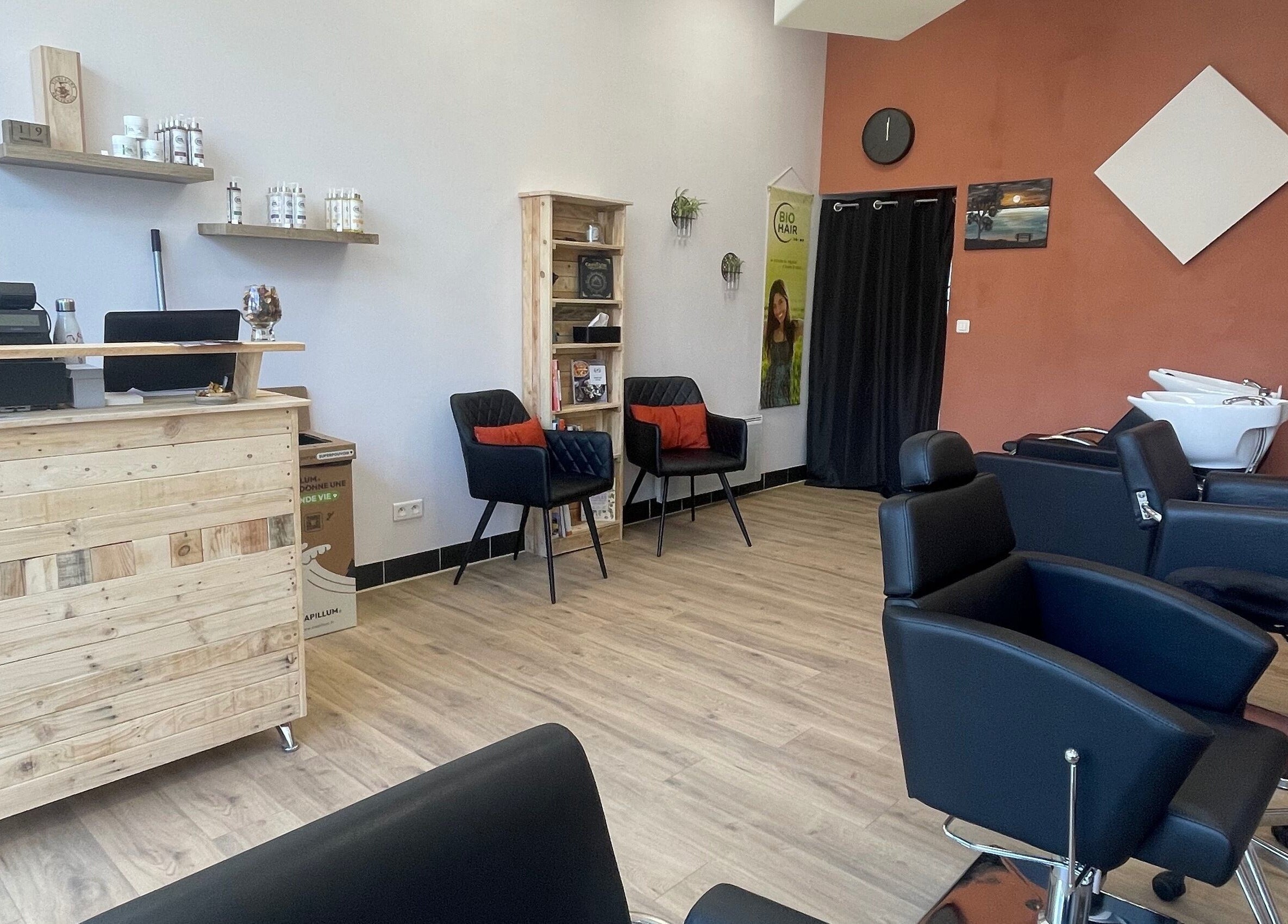 Intérieur moderne de Coiffure By Cha à Uzer, Auvergne-rhône-alpes, FR avec mobilier en bois et équipements de coiffure.