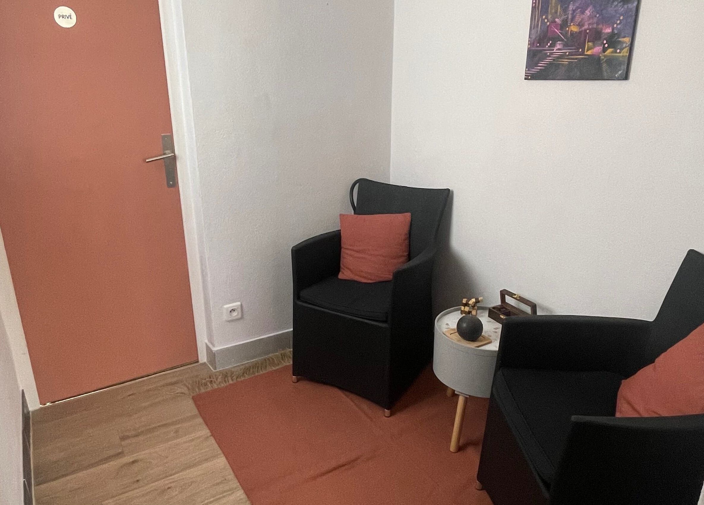 Coin détente chic chez Coiffure By Cha, Uzer, Auvergne-rhône-alpes, FR avec fauteuils noirs et déco moderne.