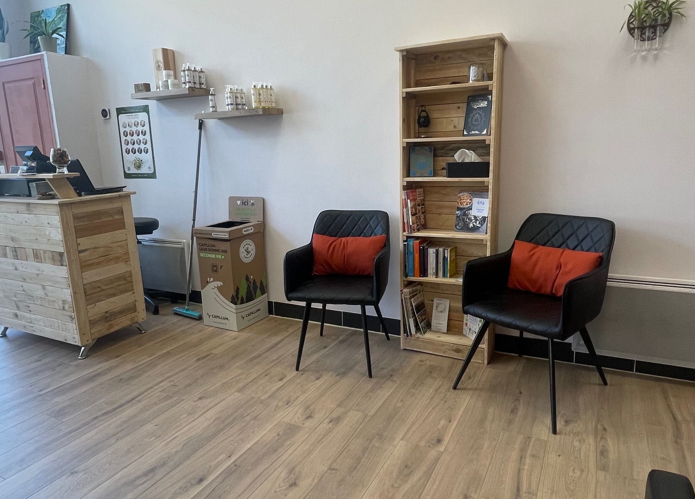Intérieur du salon Coiffure By Cha à Uzer, Auvergne-rhône-alpes, FR, avec chaises élégantes et étagère.
