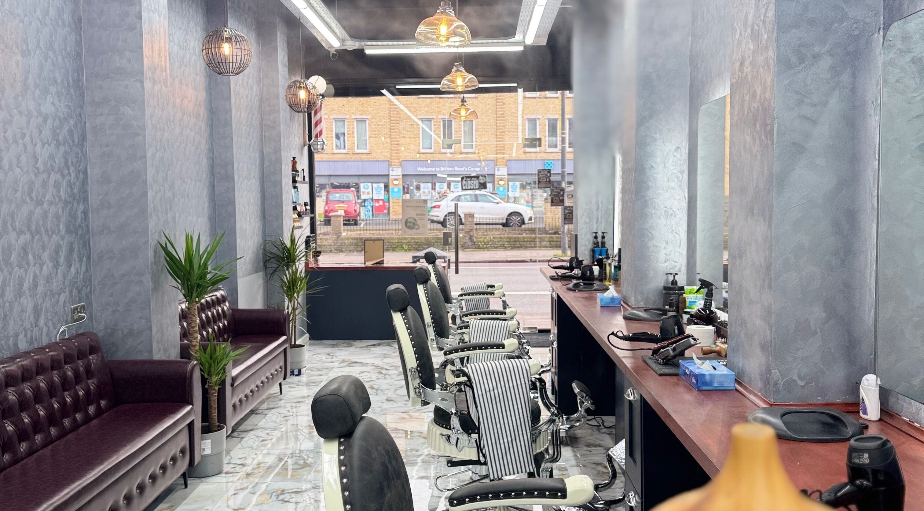 Modern interior of BRIAR BARBERS & Hairdresser in London, England, GB, featuring stylish chairs and decor.
