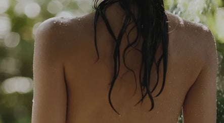 Back view of a serene woman enjoying a shower at Aesthetic Shape, Koh Phangan, TH.