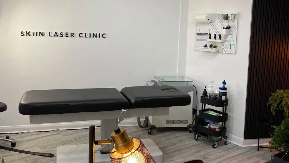 Skiin Laser Clinic treatment room in Peterborough, England, GB, featuring a modern massage table and decor.