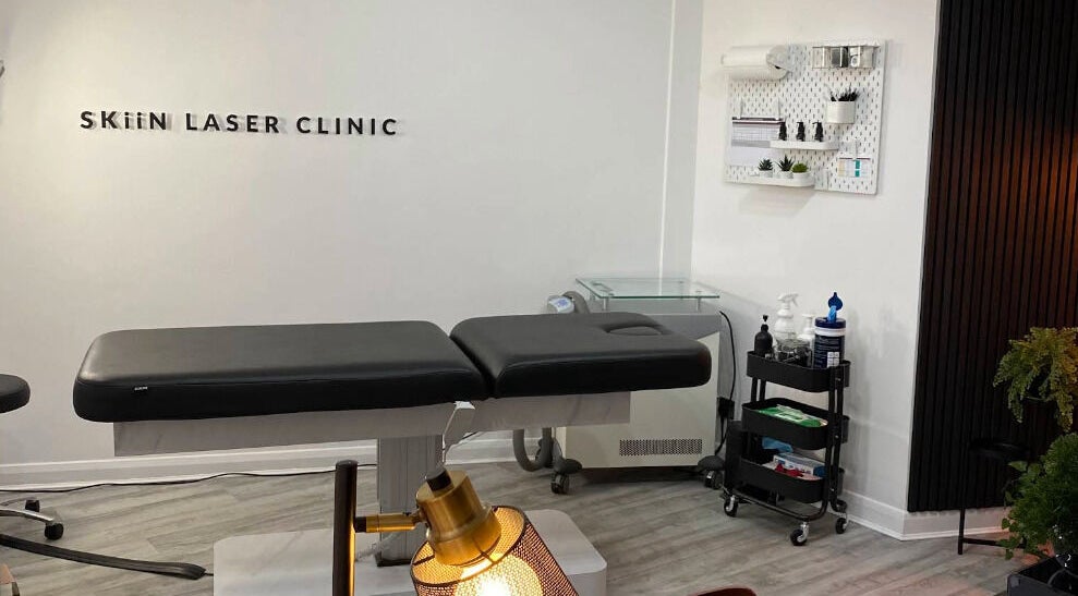 Skiin Laser Clinic treatment room in Peterborough, England, GB, featuring a modern massage table and decor.